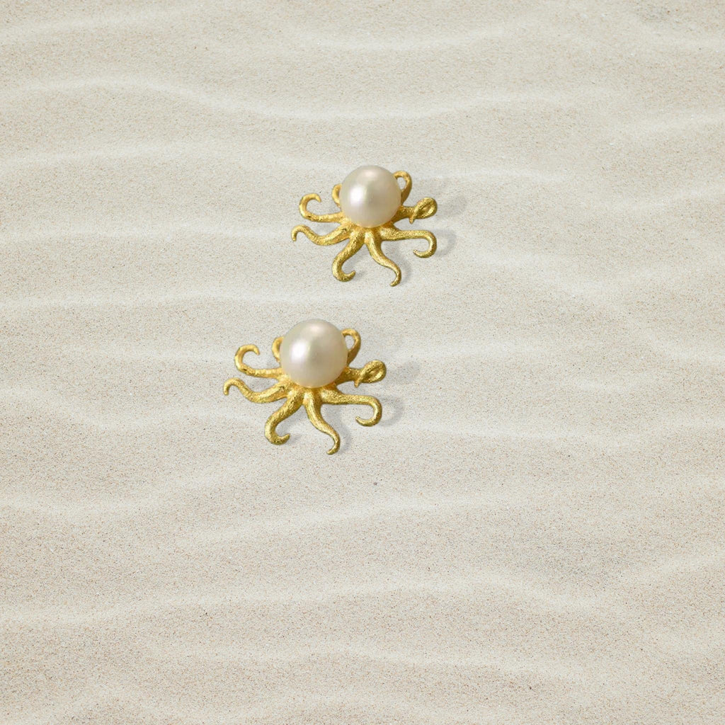 Golden Octopus Pearl Stud Earrings on sand